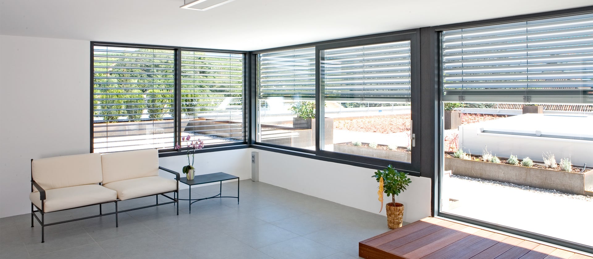 Wohnraum mit Blick nach draußen durch leicht abgedunkeltes Alu-Fenster