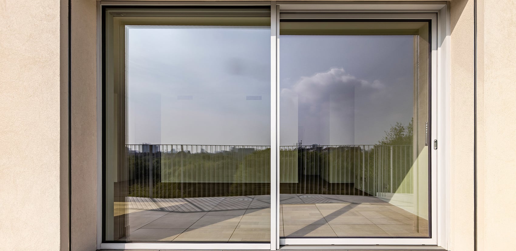 Schlanke Profilansichten und großformatige Hebeschiebetüren reduzieren die sichtbaren Rahmen auf ein Minimum und verstärken die klare Architektur des Ensembles.